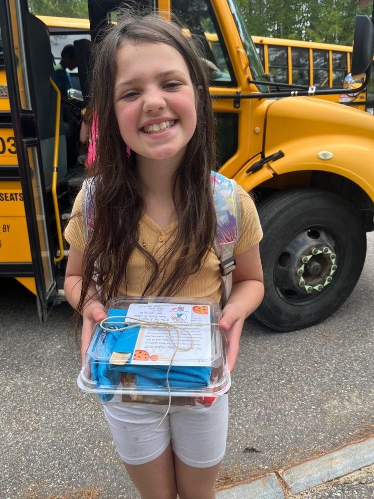 student with a cookie kit by a bus